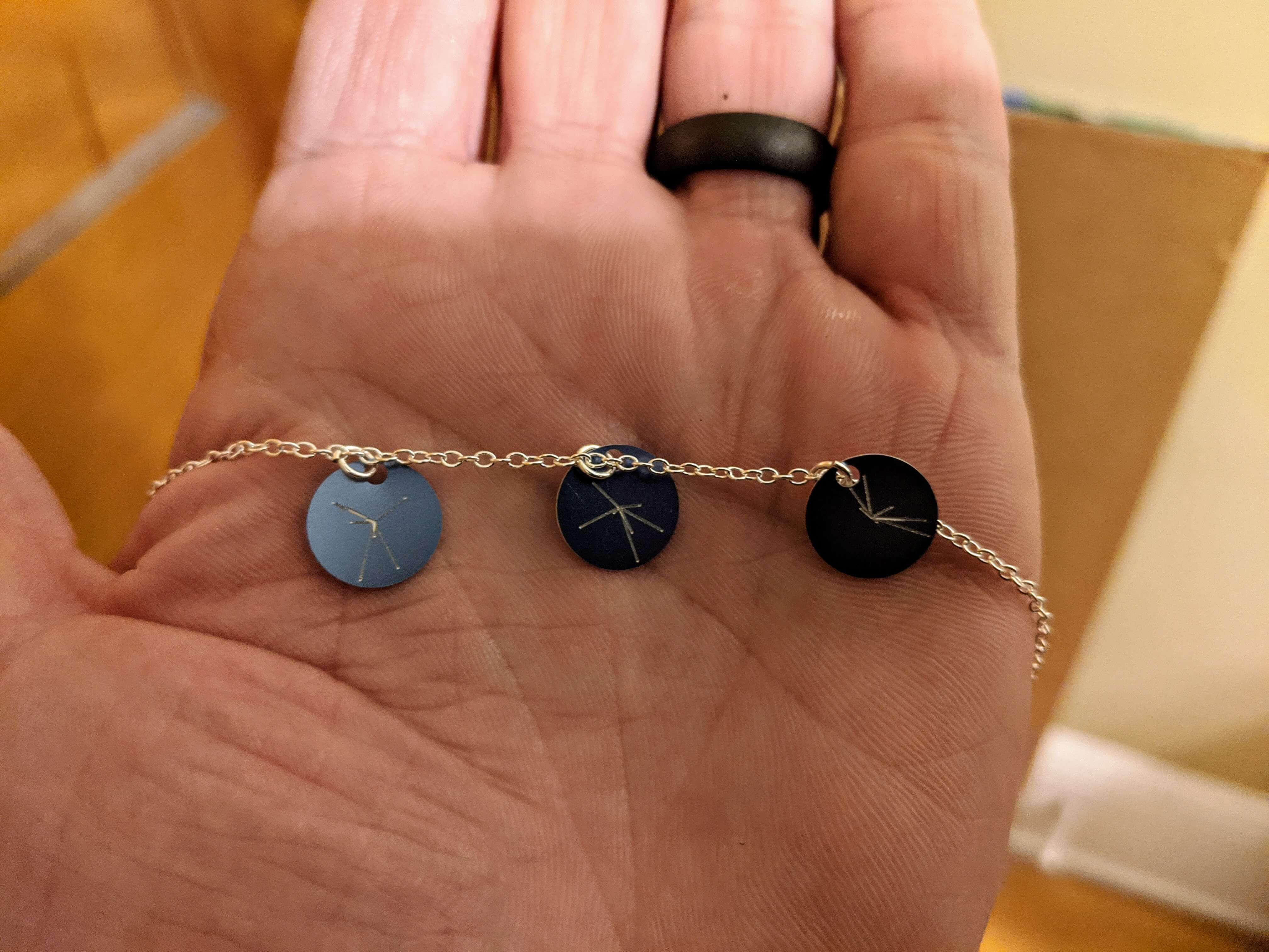 A CNC-milled necklace with planetary positions.