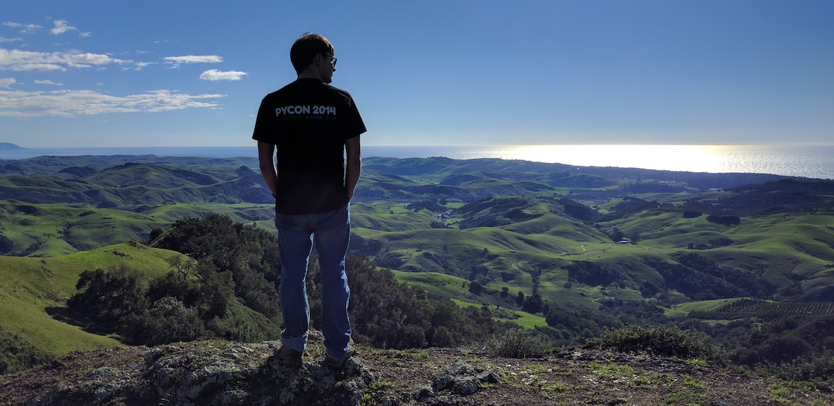 Yours truly at the top of a hill, looking over a verdant landscape.